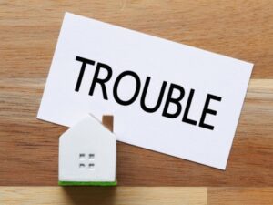 「TROUBLE」の文字と小さなお住まいのオブジェ