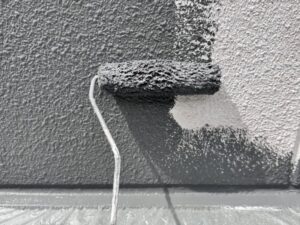 ローラーで鮮やかなグレーへと外壁を塗り替えていく瞬間